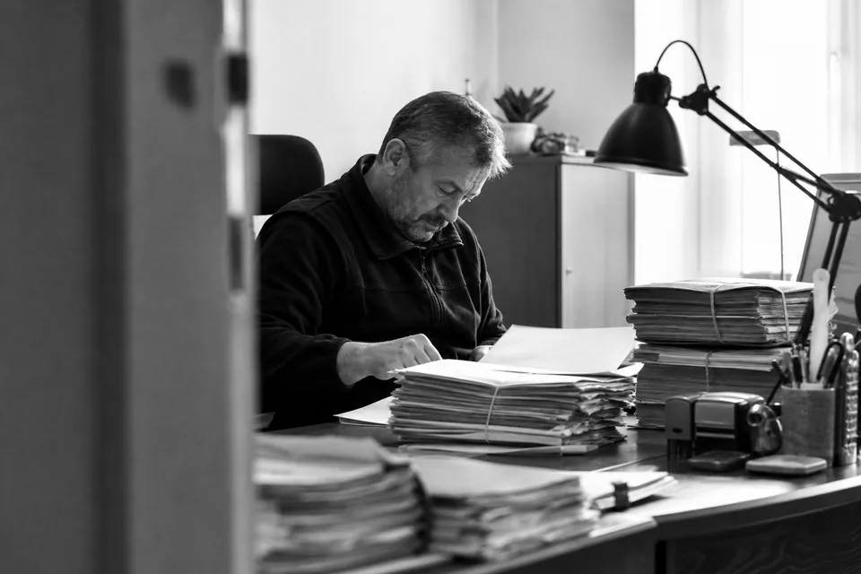 Komornik przy biurku z aktami sprawy egzekucyjnej